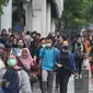 Pekerja berjalan kaki saat jam pulang di kawasan Sudirman, Jakarta, Jumat (7/2/2020). BPJS Ketenagakerjaan yang kini bernama BP Jamsostek menargetkan sekitar 23,5 juta tenaga kerja baru masuk dalam daftar kepesertaan pada 2020. (Liputan6.com/Angga Yuniar)