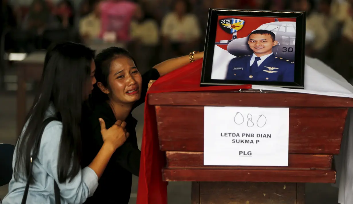 Seorang wanita menangis di samping peti mati suaminya yang menjadi korban dari jatuhnya pesawat Hercules C-130 di Medan, Rabu (1/7/2015). Peristiwa ini menambah catatan kecelakaan yang disebabkan tuanya alustista yang digunakan TNI. (REUTERS/Beawiharta)