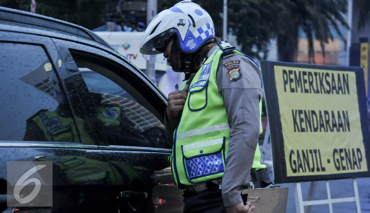 Petugas Kepolisian berbincang dengan supir yang melanggar aturan ganjil genap di Bundaran HI, Jakarta, Selasa (30/8). Sejumlah kendaraan masih didapati melanggar aturan ganjil genap yang telah resmi diberlakukan. (Liputan6.com/Yoppy Renato)