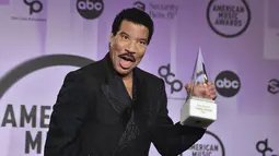 Lionel Richie berpose dengan penghargaan Icon Award di American Music Awards di Microsoft Theater di Los Angeles pada Senin (21/11/2022). Richie juga berterima kasih kepada teman-teman yang telah menjadi pendukungnya selama ini. Termasuk para penyanyi muda yang turut hadir di American Music Awards tahun ini. (AP Photo/Chris Pizzello)