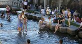 Anak-anak menyejukkan diri di air Sungai Neglinnaya saat menikmati penghujung hari yang panas di dekat Tembok Kremlin, Moskow, Rusia, 3 Juli 2022. Cuaca panas di Moskow datang dengan perkiraan suhu mencapai 30 derajat Celcius (86 Fahrenheit). (AP Photo/Alexander Zemlianichenko)