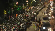 Warga berjalan di sisi deretan motor yang terparkir di ruas jalan Medan Merdeka Timur, Jakarta, Minggu (31/12). Akibat banyaknya motor yang parkir, ruas jalan Medan Merdeka Timur menyempit dan terjadi kemacetan panjang. (Liputan6.com/Helmi Fithriansyah)