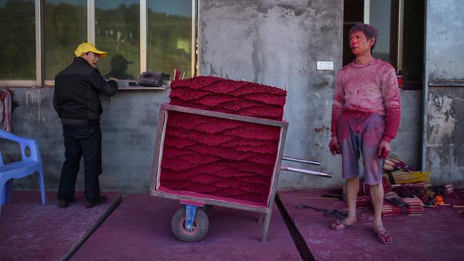 Gambar pada 11 Desember 2019, pekerja  menunggu untuk menimbang dupa yang dia produksi di Pabrik Dupa Fujian Xingquan, Provinsi Fujian, China. Mendekati liburan Tahun Baru Imlek, ini adalah waktu yang penting tahun bagi penduduk desa ini yang memasok banyak dupa dunia. (HECTOR RETAMAL/AFP)