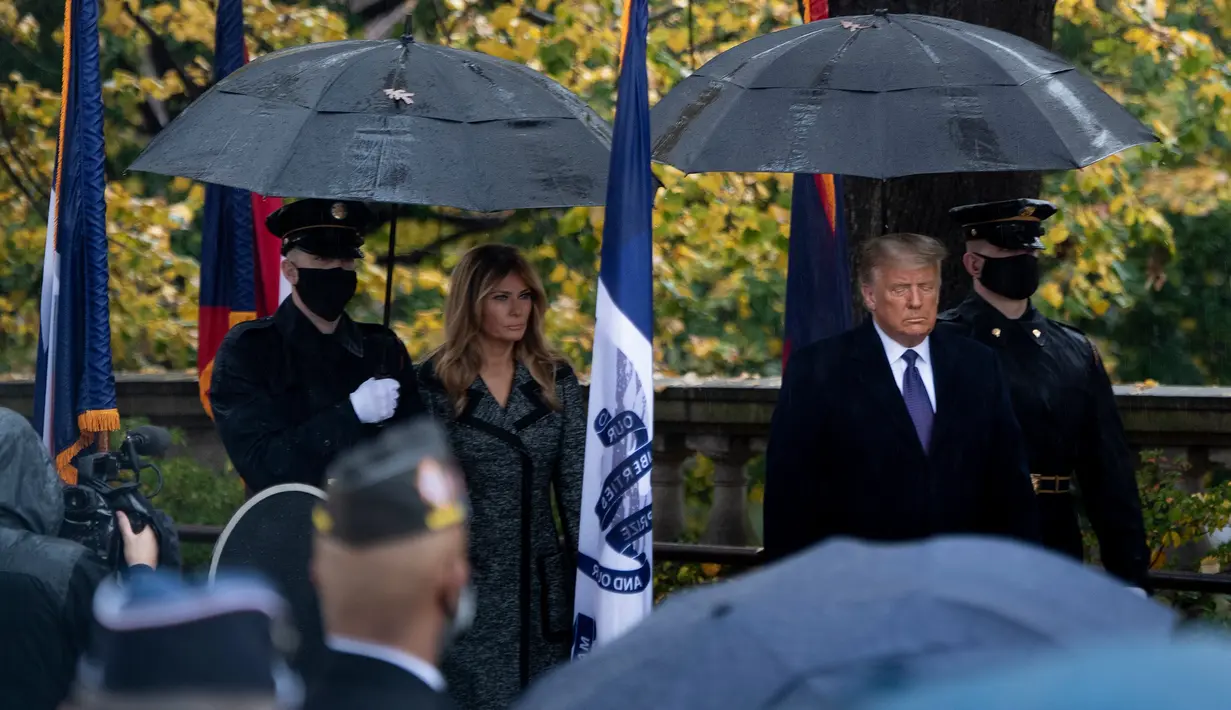 Ibu Negara AS Melania Trump dan Presiden Donald Trump tiba untuk upacara peletakan karangan bunga di Makam Prajurit Tidak Dikenal pada Hari Veteran di Pemakaman Nasional Arlington di Arlington, Virginia, Rabu (11/11/2020). (Brendan Smialowski/AFP)