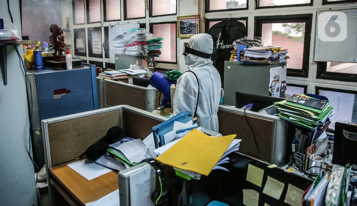 Petugas melakukan penyemprotan cairan disinfektan di ruangan kerja Gedung KPU Pusat, Jakarta, Selasa (21/7/20).  Penyemprotan dilakukan setelah seorang pegawai Komisi Pemilihan Umum (KPU) RI terpapar virus Covid-19. (Liputan6.com/Faizal Fanani)