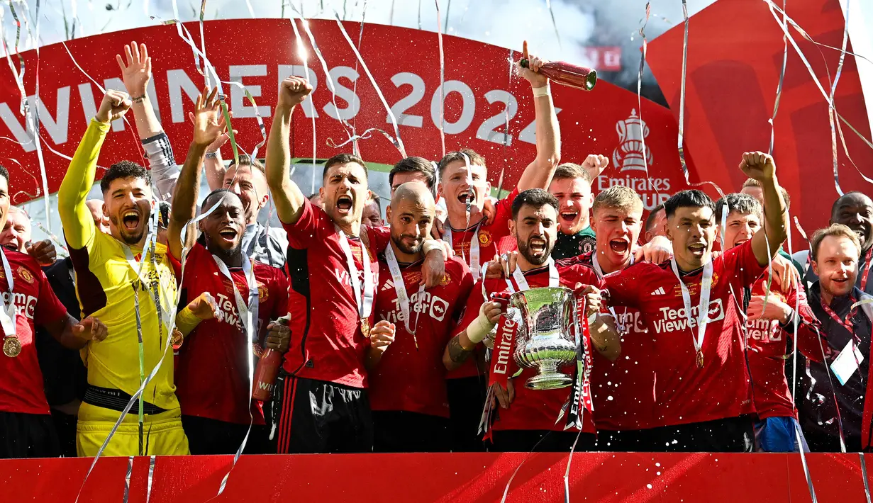 Selebrasi para pemain Manchester United dengan trofi Piala FA 2023/2024 setelah mengalahkan Manchester City 2-1 pada laga final di Wembley Stadium, London, Sabtu (25/5/2024). (AFP/Justin Tallis)