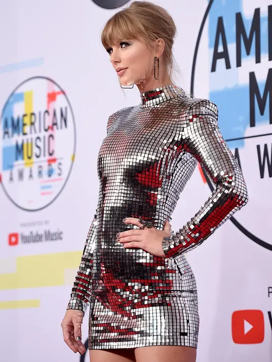 Penyanyi Taylor Swift menghadiri ajang American Music Awards 2018 di Los Angeles, Selasa (9/10). Mengenakan mini dress silver dari Balmain, Taylor langsung menjadi pusat perhatian begitu melangkah di red carpet. (Kevork Djansezian/Getty Images/AFP)