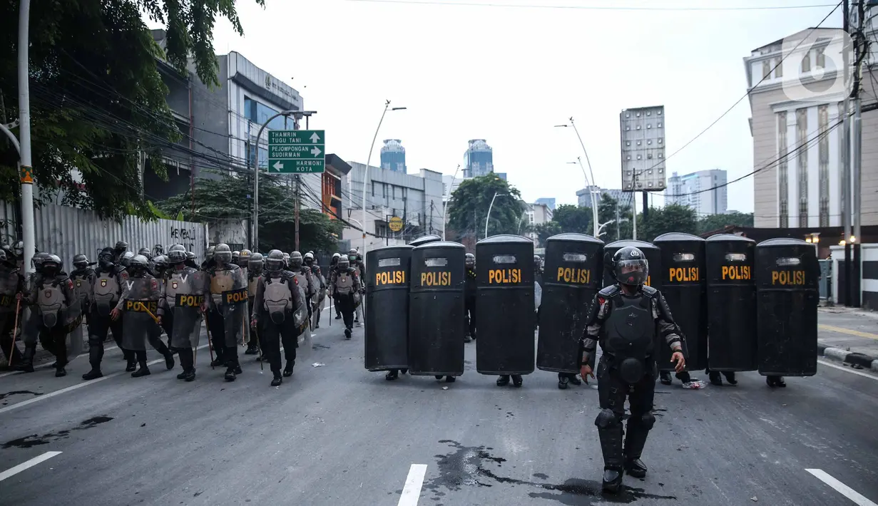 Anggota brimob memukul mundur massa aksi di kawasan Tanah Abang, Jakarta, Selasa (13/10/2020). Hingga menjelang magribh massa masih melakukan perlawan di kawasaan tersebut. (Liputan6.com/Faizal Fanani)