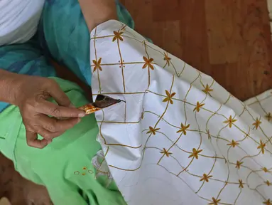 Perajin menyelesaikan salah satu tahapan produksi batik Marunda di Rusunawa Marunda, Jakarta, Selasa (14/7/2020). Batik Marunda merupakan kreasi para ibu di tiga rusun sewa. (Liputan6.com/Herman Zakharia)
