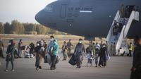Pengungsi dari Afghanistan turun dari pesawat angkatan udara AS di Naval Station di Rota, Spanyol selatan, Selasa (31/8/2021).  Amerika Serikat menyelesaikan penarikannya dari Afghanistan Senin malam, mengakhiri perang terpanjang Amerika. (AP Photo/Marcos Moreno)