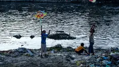 Anak laki-laki menerbangkan layang-layang di tepi sungai menjelang festival Hindu Dashain di Kathmandu (7/10/2020). Festival ini yang paling dinantikan di Nepal, Bhutan, Burma, dan perbukitan India Utara. (AFP/Prakash Mathema)
