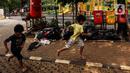 Anak-anak berlari di samping tumpukan sampah saat bermain di Ruang Publik Terpadu Ramah Anak (RPTRA) Berseri, Petukangan Utara, Pesanggrahan, Jakarta, Kamis (13/7/2023). Kendati banyak cat pada wahan permainan yang mulai pudar dan kotor, tapi tidak menyurutkan minat anak-anak untuk bermain di RPTRA Berseri. (Liputan6.com/Johan Tallo)