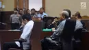 Terdakwa korupsi proyek E-KTP Setya Novanto (kiri) tertunduk saat tim dokter membacakan hasil pemeriksaan kesehatan pada lanjutan sidang perdana, Pengadilan Tipikor, Jakarta, Rabu (13/12). Setya Novanto dinyatakan sehat. (Liputan6.com/Helmi Fithriansyah)