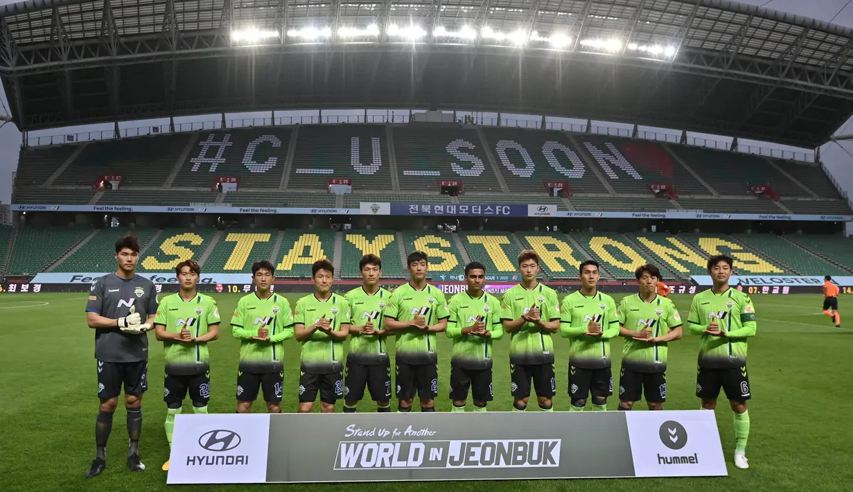 Pemain Jeonbuk Hyundai Motors memberikan aplaus saat melawan Suwon Samsung Blue Wings pada laga K-League di Stadion Jeonju, Korea Selatan, Jumat (8/5/2020). Kembali bergulir di tengah wabah corona, K-League tanpa penonton. (AFP/Jung Yeon-Je)