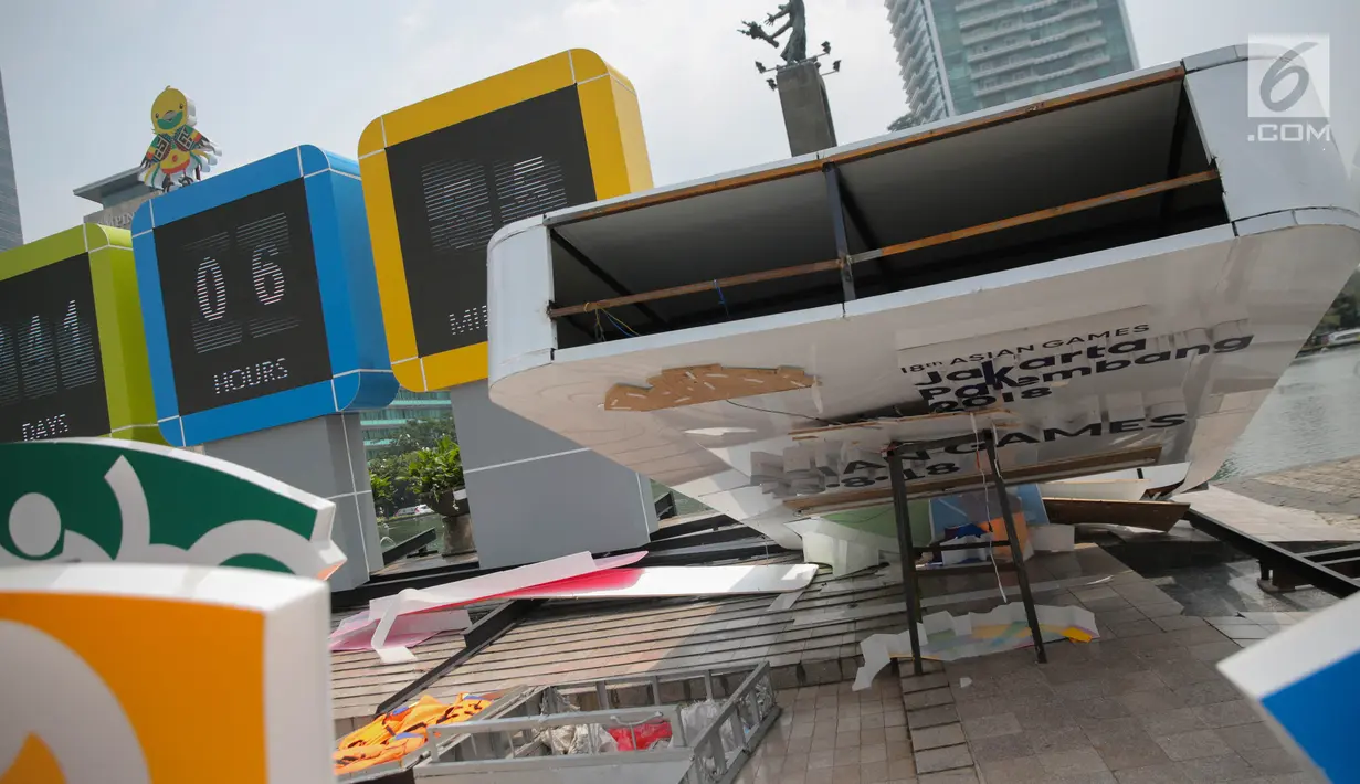 Kondisi papan sosialisasi Asian Games 2018 yang roboh akibat hujan angin di Bundaran HI, Jakarta, Senin (11/9). Kontruksi besi penahan baliho patah Akibat hujan angin yang mengguyur Jakarta minggu (10/9) malam. (Liputan6.com/Faizal Fanani)