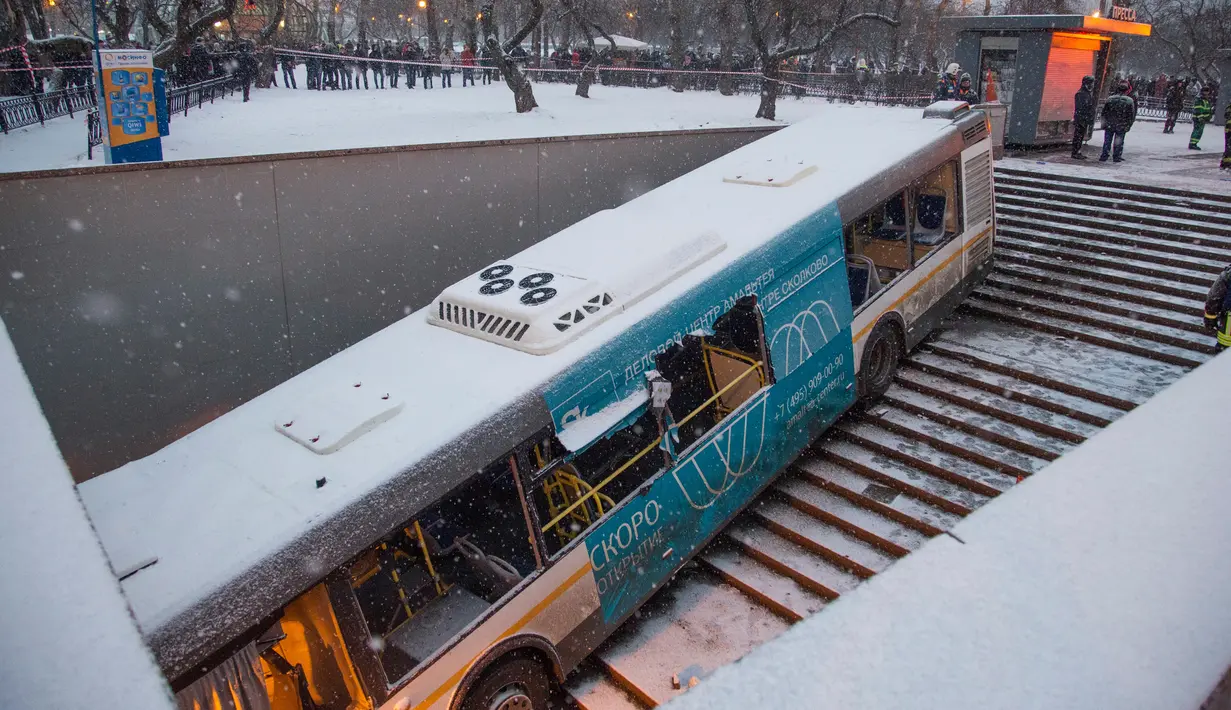Sejumlah orang melihat lokasi sebuah bus yang menorobos underpass khusus pejalan kaki di Moskow, Rusia, Senin (25/12). Bus sempat menabrak beberapa pejalan kaki yang sedang menuruni tangga di stasiun bawah tanah. (AP/Ivan Sekretarev)