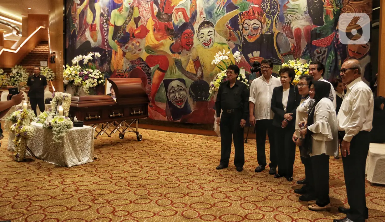 Sejumlah keluarga dan kerabat berfoto dekat dekat peti jenazah almarhum pengusaha Ciputra saat disemayamkan di Gedung Ciputra Artpreneur, Jakarta, Kamis (28/11/2019). Pendiri Ciputra Group tersebut meninggal pada usia 88 tahun di Rumah Sakit Gleneagles, Singapura. (Liputan6.com/Johan Tallo)