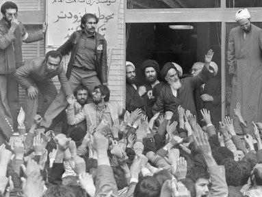 Pemimpin spiritual Iran, Ayatollah Khomeini (tengah) melambaikan tangan kepada pengikutnya ketika dia muncul di balkon markas besarnya di Teheran, Iran, 1 Februari 1979. Ayatullah Khomeini memimpin Revolusi Islam Iran. (AP Photo/Campion, File)