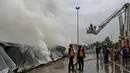 Petugas pemadam terus berupaya untuk melakukan pemadaman dan pendinginan di kawasan tersebut. (Aamir Qureshi/AFP)