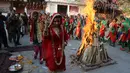 Gadis-gadis India berpakaian tradisional menari mengelilingi api unggun saat merayakan festival Lohri di Jammu, India (13/1). Dimana siang hari sangat pendek dan malam hari sangat panjang pada hari itu. (AP Photo / Channi Anand)