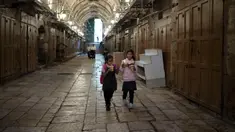 Gadis-gadis Palestina makan mie saat mereka berjalan pulang dari sekolah melalui deretan toko yang ditutup untuk pemogokan umum yang menyerukan gencatan senjata di Gaza di Kota Tua Yerusalem, Senin (11/12/2023). (AP Photo/Maya Alleruzzo)