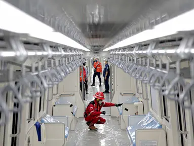 Petugas mengecek kesiapan gerbong kereta listrik saat uji coba di stasiun LRT TMII, Jakarta, Rabu (11/11/2020). Tes dilakukan mulai dari uji kelayakan hingga kebisingan. Ditargetkan LRT Jabodebek beroperasi pertengahan 2022. (Liputan6.com/Faizal Fanani)