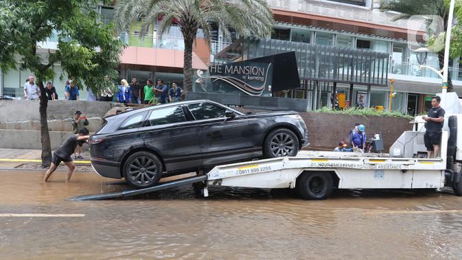 Sebuah mobil dipindahkan setelah terendam banjir di kawasan Kemang, Jakarta, Kamis (2/1/2020). Banjir yang melanda Jakarta dan sekitarnya mengakibatkan banyak kendaraan terendam air. (Liputan6.com/Herman Zakharia)