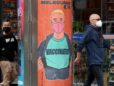 Orang-orang berjalan melewati poster yang mendorong vaksinasi di Melbourne, Australia, Kamis (30/9/2021). Melbourne bergulat dengan lonjakan infeksi Covid-19 di mana sebanyak 1.438 kasus dilaporkan, jumlah harian terbesar sejak awal pandemi. (William WEST / AFP)