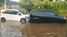 Mobil milik warga terendam banjir yang menggenangi kawasan Perumahan Pantai Mutiara, Jakarta, (4/6). Tingginya pasang air laut menyebabkan tanggul di Jalan Mutiara 1, Pluit, Penjaringan, sepanjang sekitar 50 meter jebol. (Liputan6.com/Gempur M Surya)