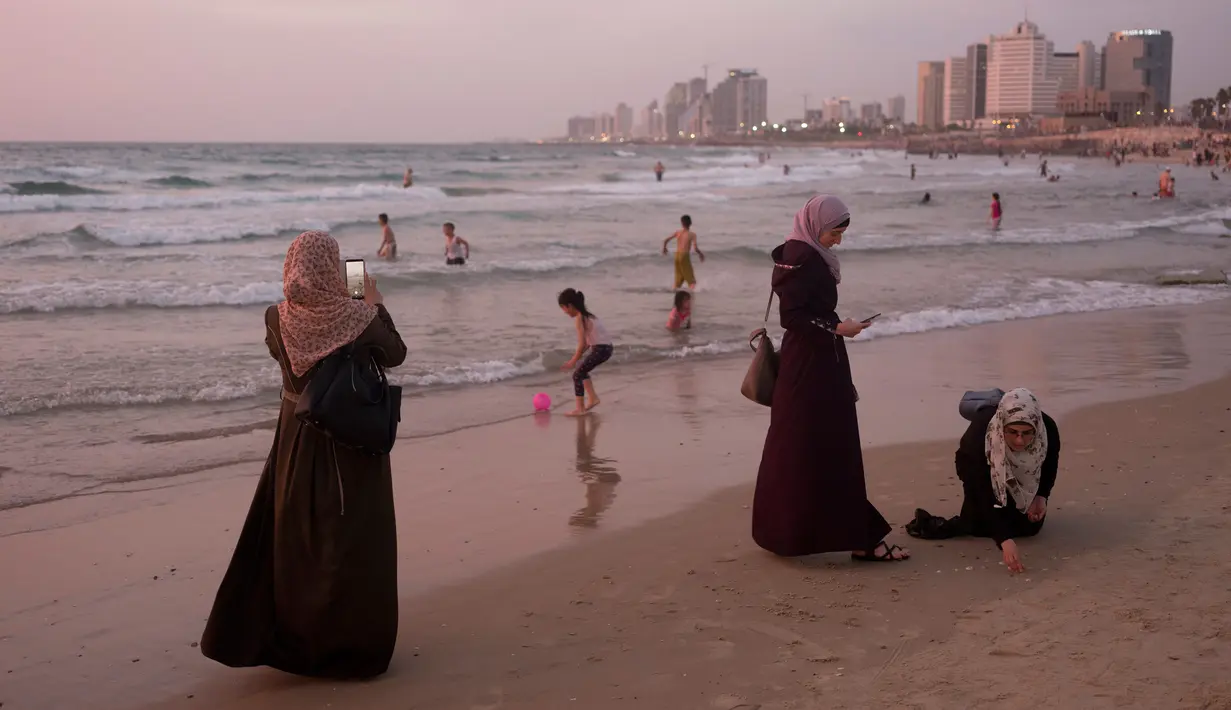Muslim Palestina menghabiskan hari libur Lebaran di pantai Tel Aviv, Israel, 6 Juni 2019. Selama Idul Fitri, warga Palestina mengunjungi pantai di kawasan Tel Aviv untuk menandai berakhirnya ibadah puasa Ramadan. (AP Photo/Oded Balilty)