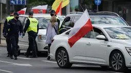Para pengusaha memblokir jalan dengan mobil mereka saat berdemonstrasi di Warsawa, Polandia, Kamis (7/5/2020). Para pengusaha mendesak pemerintah lebih banyak dalam membantu bisnis mereka agar mampu bertahan menghadapi pandemi virus corona COVID-19.(JANEK SKARZYNSKI/AFP)