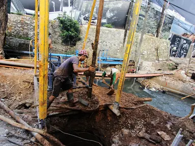 Pekerja menyelesaikan proyek peninggian jembatan Kali Mampang di kawasan Jalan Warung Buncit Raya, Jakarta, Kamis (5/6/14). (Liputan6.com/Faizal Fanani)