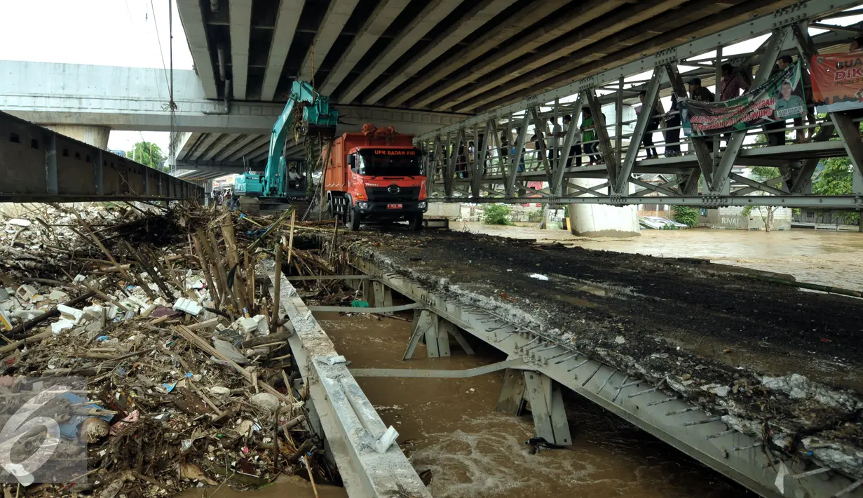 Alat berat dan truk mengangkut tumpukan sampah di jembatan Rawajati Kalibata, Jakarta, Selasa (8/3/2016). Hujan yang mengguyur Bogor dua hari terakhir mengakibatkan banjir kiriman yang disertai sampah batang bambu. (Liputan6.com/Helmi Fithriansyah)