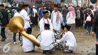Tim Tanjidor beristirahat di tengah kerumunan saat Festival Lebaran Betawi IX di Lapangan Banteng, Jakarta, Minggu (14/8). Lebaran Betawi mulai diselenggarakan tahun 2008 dan terus ada hingga kini. (Liputan6.com/Immanuel Antonius) 