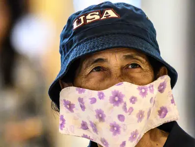 Seorang pengunjung mengenakan masker pelindung di tengah kekhawatiran penyebaran virus corona COVID-19 di sebuah toko di Bangkok, Thailanda (17/2/2020). Penggunaan masker merupakan salah satu cara untuk mengantisipasi penyebaran virus corona. (AFP/Mladen Antonov)