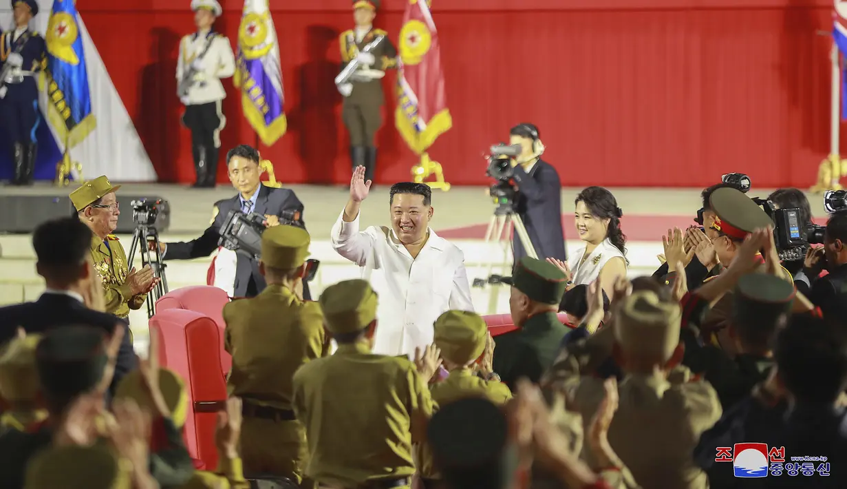 Pemimpin Korea Utara Kim Jong-un (tengah) melambaikan tangan kepada para peserta saat upacara untuk menandai peringatan ke-69 tahun penandatanganan gencatan senjata yang mengakhiri pertempuran dalam Perang Korea di Pyongyang, Korea Utara, 27 Juli 2022. Korea Selatan dan Korea Utara memperingati gencatan senjata yang disepakati keduanya. (Korean Central News Agency/Korea News Service via AP)