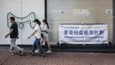 Sejumlah orang berjalan melewati pusat pengujian virus corona COVID-19 di Hong Kong, Selasa (1/9/2020). Hong Kong mulai melakukan tes massal virus corona COVID-19. (ISAAC LAWRENCE/AFP)