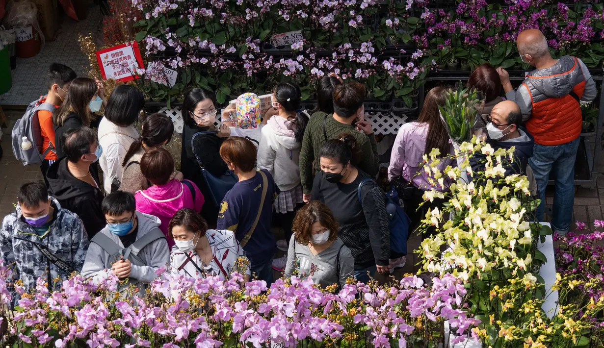 Orang-orang memilih bunga di pasar menjelang Tahun Baru Imlek di daerah Prince Edward Hong Kong (16/1/2022). Tahun Baru Imlek China jatuh pada 1 Februari 2022. (AFP/Bertha Wang)