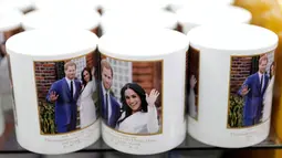 Suvenir mug untuk pernikahan Pangeran Harry dan Meghan Markle dijual di sebuah toko di London, Inggris, Rabu (28/3). Pernikahan Pangeran Harry dan Meghan Markle berlangsung pada 19 Mei 2018. (AP Photo/Matt Dunham)