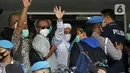 Rizieq Shihab (tengah) melambaikan tangan sesaat sebelum masuk gedung utama Mapolda Metro Jaya, Jakarta, Sabtu (12/12/2020). Rizieq Shihab akan menjalani pemeriksan sebagai tersangka penghasutan dan kerumunan di tengah pandemi Covid-19. (Liputan6.com/Helmi Fithriansyah)