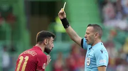 Gelandang Portugal, Bruno Fernandes mendapatkan kartu kuning dari Wasit Orel Grinfeeld saat bertanding melawan Swiss pada pertandingan kedua Grup A2 UEFA Nations League di Stadion Jose Alvalade di Lisbon, Senin (6/6/2022). Portugal menang telak atas Swiss 4-0. (AP Photo/Armando Franca)