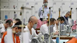 Para tahanan menggunakan mesin jahit saat membuat masker di Penjara Taipei di Kota Taoyuan, Taiwan utara (10/3/2020). Taiwan berhasil mempertahankan jumlah kasus virus corona yang dikonfirmasi menjadi 45 dan satu kematian. (AFP/Sam Yeh)