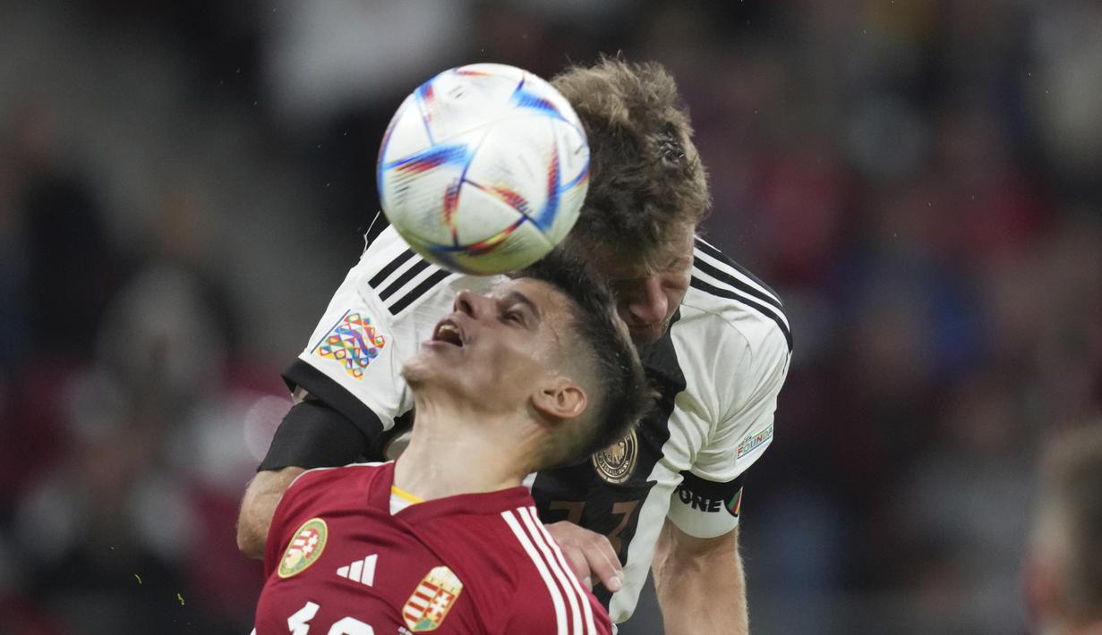 Pemain Hungaria Milos Kerkez berebut bola dengan pemain Jerman Thomas Muller selama pertandingan UEFA Nations League di Red Bull Arena di Leipzig, Jerman, Jumat, 23 September 2022. Hungaria bertahan di puncak dengan 10 poin, unggul dua poin dari Italia yang baru saja mengalahkan Inggris 1-0. (AP Photo/Michael Sohn)