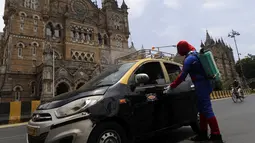 Pekerja sosial India Ashok Kurmi berpakaian seperti Spider Man mendesinfeksi taksi di dekat stasiun kereta Chhatrapati Shivaji Maharaj selama lockdown yang diberlakukan di Mumbai, Rabu (21/4/2021). Kegiatan tersebut dilakukan untuk mengekang penyebaran COVID-19 di Mumbai. (AP Photo/Rajanish Kakade)