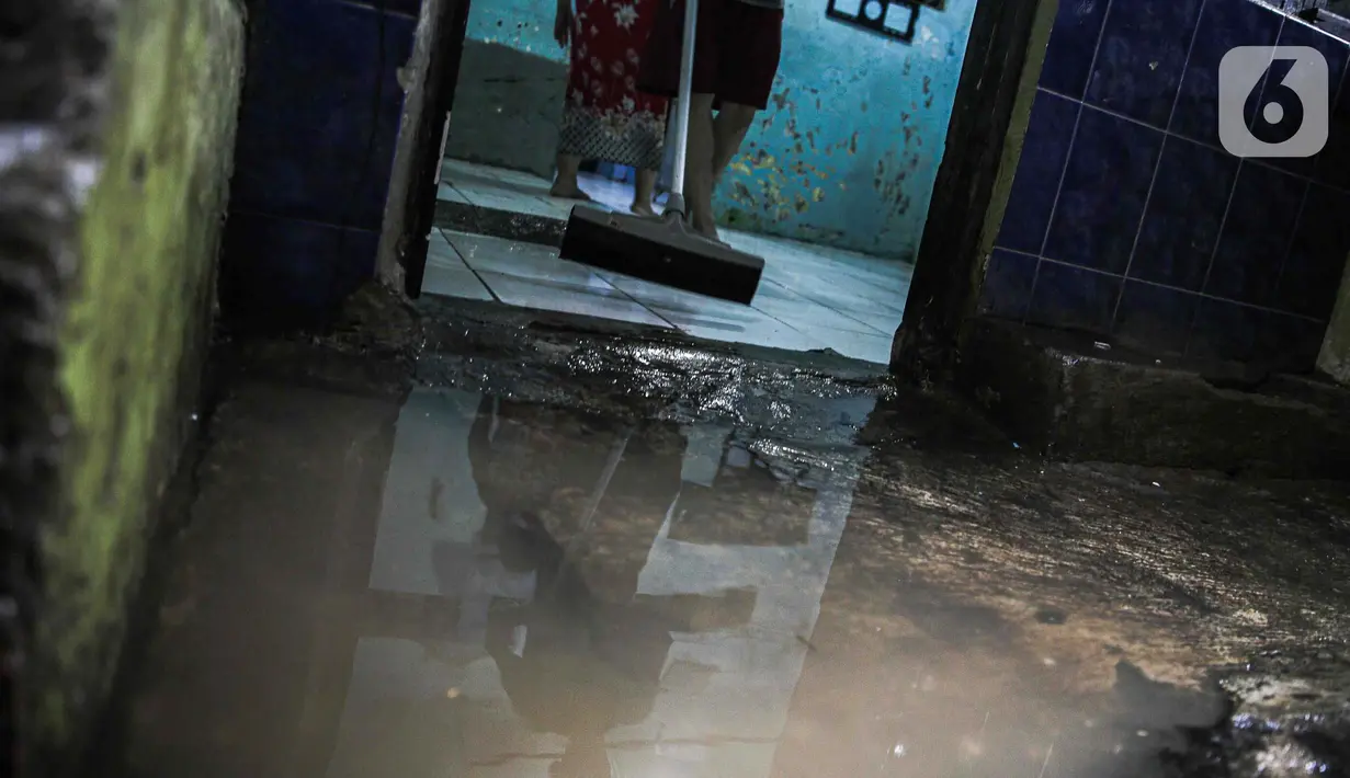 Warga membersihkan sisa-sisa lumpur akibat banjir di kawasan pemukiman padat penduduk Kebon Pala, Kampung Melayu, Jakarta, Jumat (1/12/2023). (Liputan6.com/Faizal Fanani)