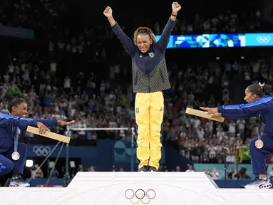Dua pesenam Amerika Serikat, Simone Biles dan Jordan Chiles merayakan kemenangan pesenam Brasil, Rebeca Andrade pada cabang olahraga senam Olimpiade Paris 2024 di Bercy Arena, Paris, Prancis, Senin (05/08/2024). (AP Photo/Abbie Parr)