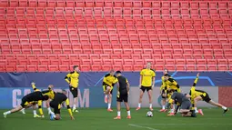 Para pemain Borussia Dortmund melakukan pemanasan saat mengikuti sesi latihan di stadion Ramon Sanchez Pizjuan di Seville (16/2/2021).  Die Borussen, julukan Dortmund, saat ini dalam performa kurang baik karena dalam dua laga terakhir belum memetik kemenangan. (AFP/Cristina Quicler)
