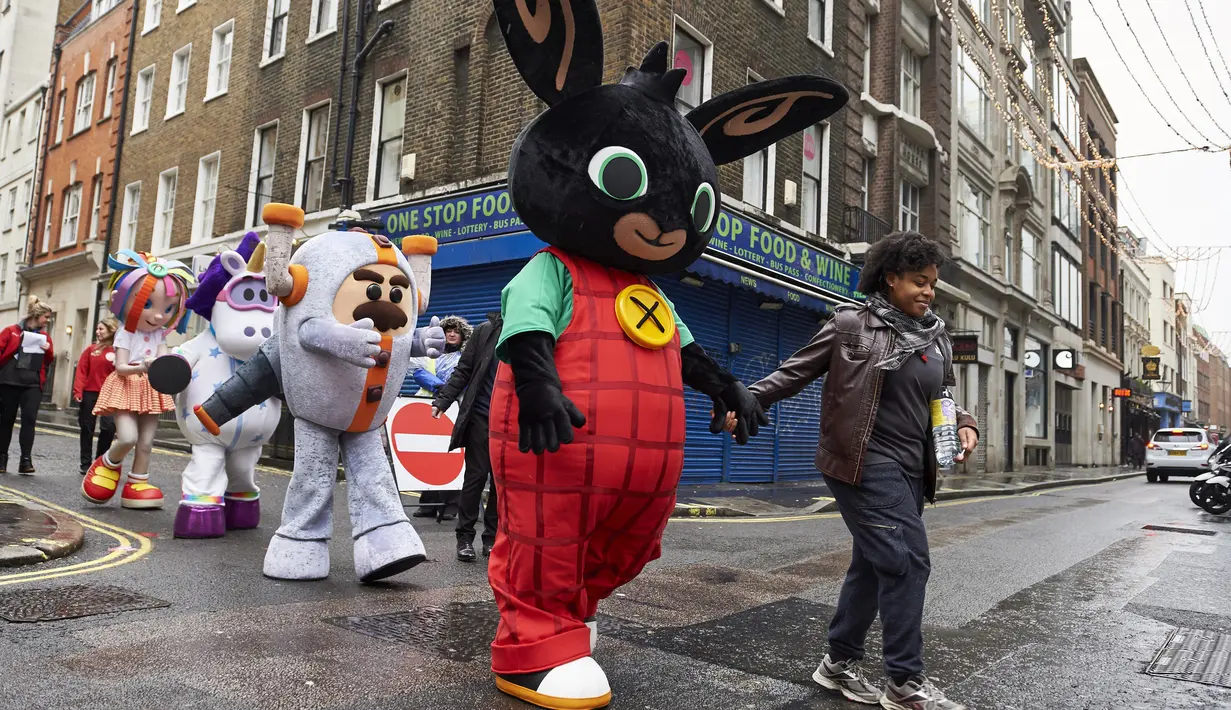 Para peserta mengenakan kostum tokoh hiburan anak berjalan untuk mengikuti Hamleys Natal Toy Parade di Regent Street di London, Inggris (20/11). Parade ini menghadirkan sejumlah karakter kartun dan mainan yang populer dikalangan anak. (AFP/Niklas Halle'n)