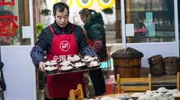 Warga lokal Kota Kuno Zhongshan membuat makanan tradisional untuk merayakan Tahun Baru Imlek di Distrik Jiangjin, Chongqing, China, Jumat (17/1/2020).  (Xinhua/Liu Chan)