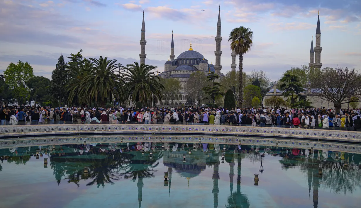 Umat ​​Islam bersiap untuk mengikuti salat subuh pada hari pertama Idul Fitri, yang menandai berakhirnya bulan suci Ramadhan, di Masjid Biru di Istanbul, Turki, Jumat (21/4/2023). (Photo by Yasin AKGUL / AFP)